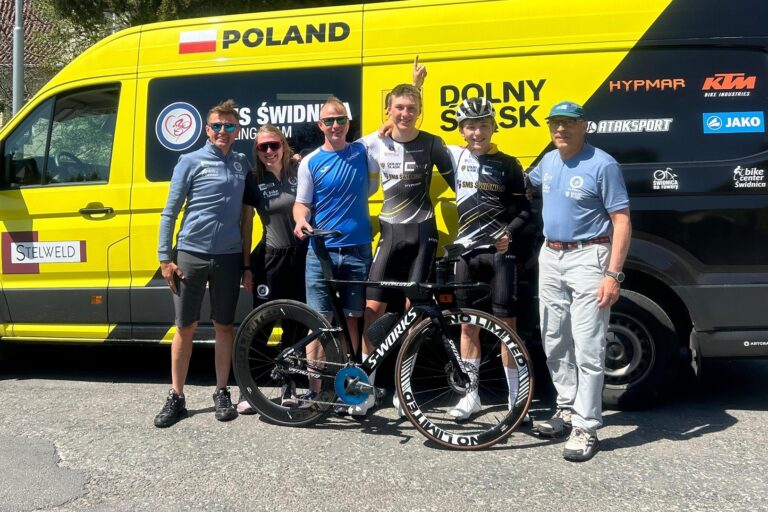 Leon Janikowski z ekipą i rowerem torowym na tle żółtego busa reprezentacji Polski po zwycięstwie w Wyścigu Pokoju U17